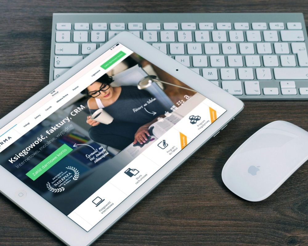 A tablet with a financial website open, alongside a white keyboard and mouse. Ideal for tech-theme stock images.